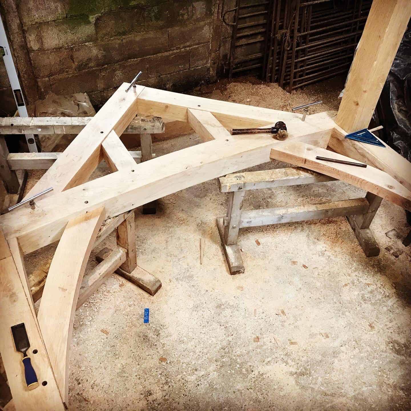 Oak elements being assembled on a workbench with tools scattered around.