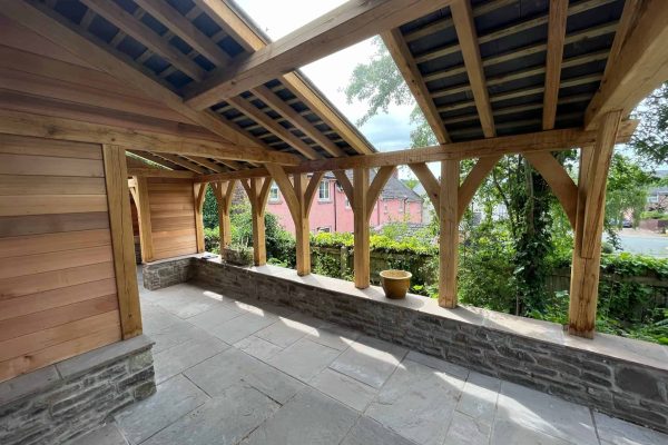 A wooden shelter with an open wall overlooking a residential area is made of oak.