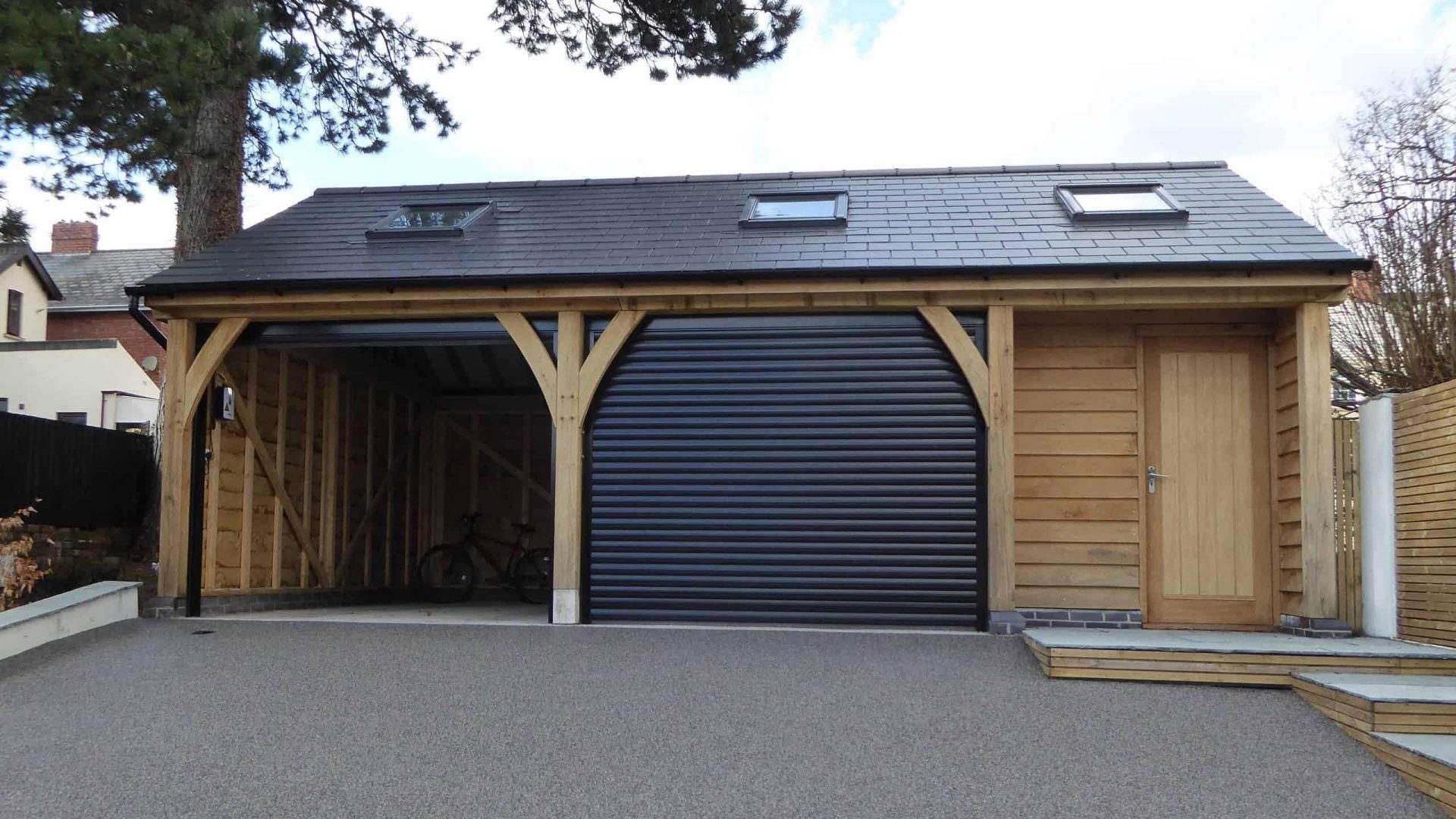 An oak wooden carport with a storage room on the side and a rolling garage door.