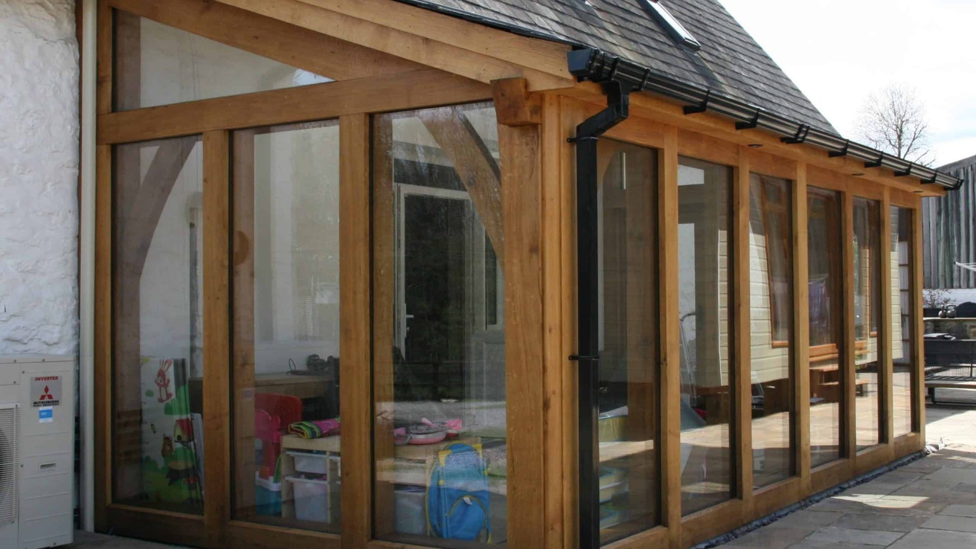 Modern oak conservatory with large glass windows and a sloped roof.